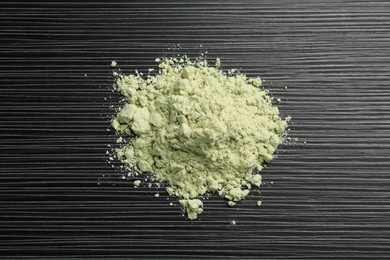 Photo of Pile of wasabi powder on black textured table, top view