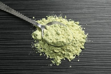 Photo of Pile of wasabi powder and spoon on black textured table, top view