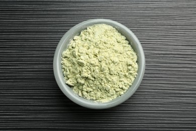 Photo of Wasabi powder in bowl on black textured table, top view