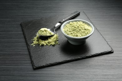 Photo of Dry wasabi powder and spoon on black textured table