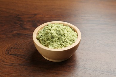 Photo of Dry wasabi powder in bowl on wooden table