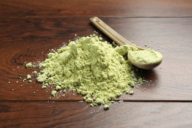 Photo of Pile of dry wasabi powder and spoon on wooden table, closeup