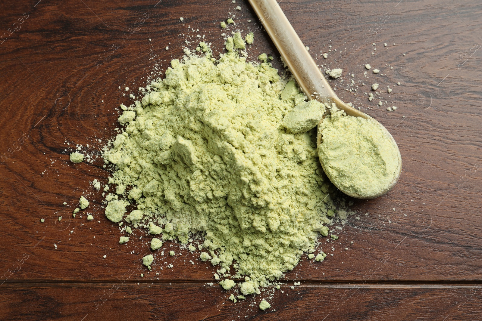 Photo of Pile of dry wasabi powder and spoon on wooden table, top view