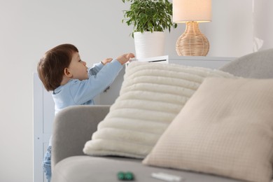 Photo of Little boy finding cabinet with pills at home. Child in danger