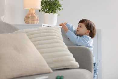 Photo of Little boy playing with pills at home. Child in danger