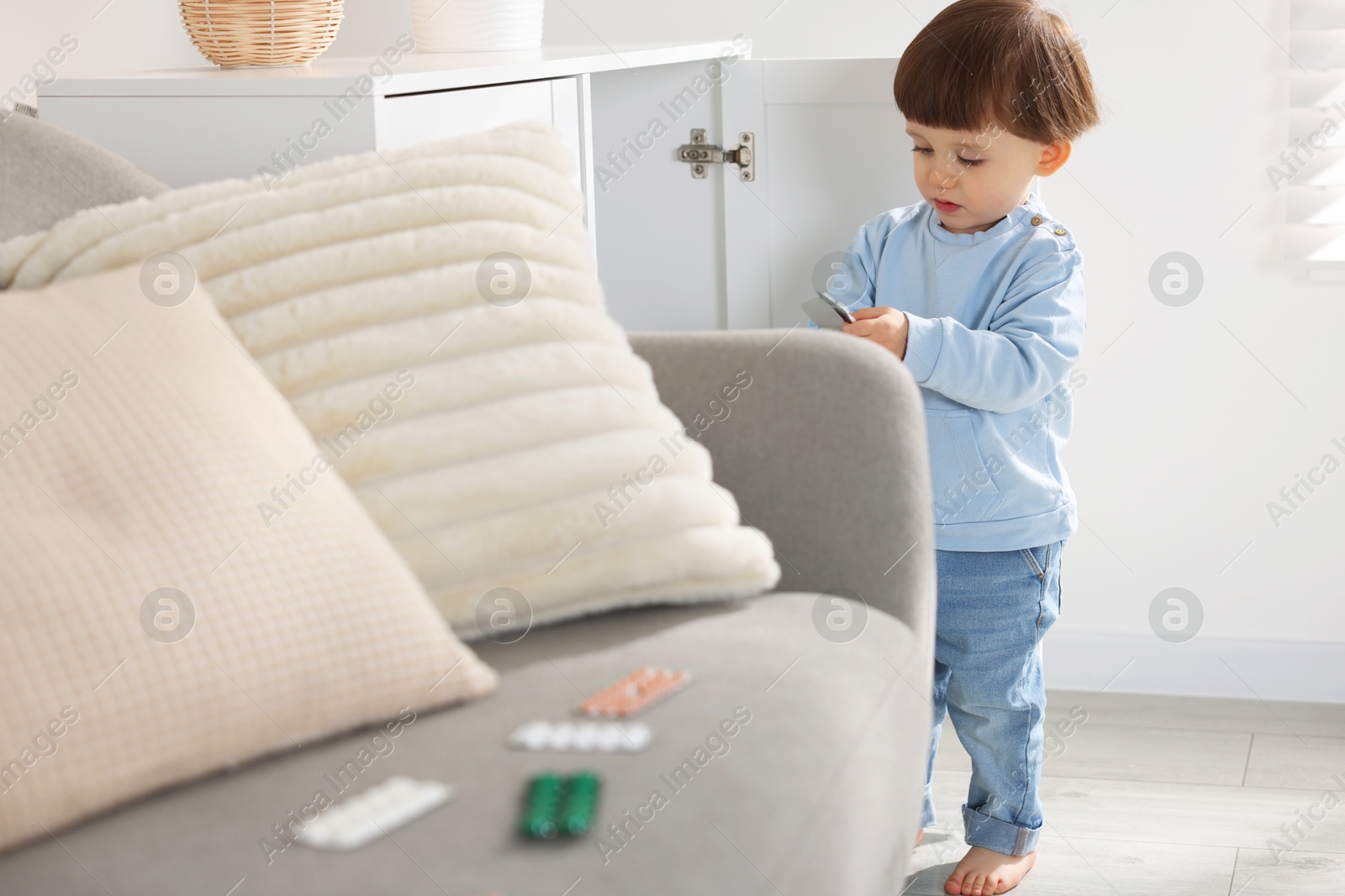 Photo of Little boy with pills at home. Child in danger