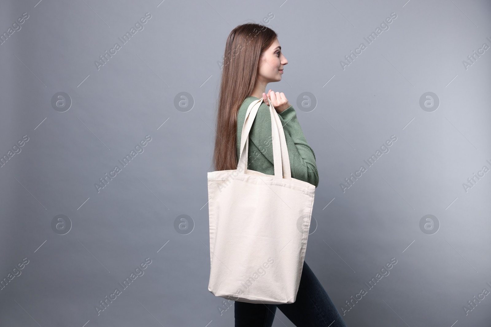 Photo of Woman with blank shopper bag on grey background. Mockup for design