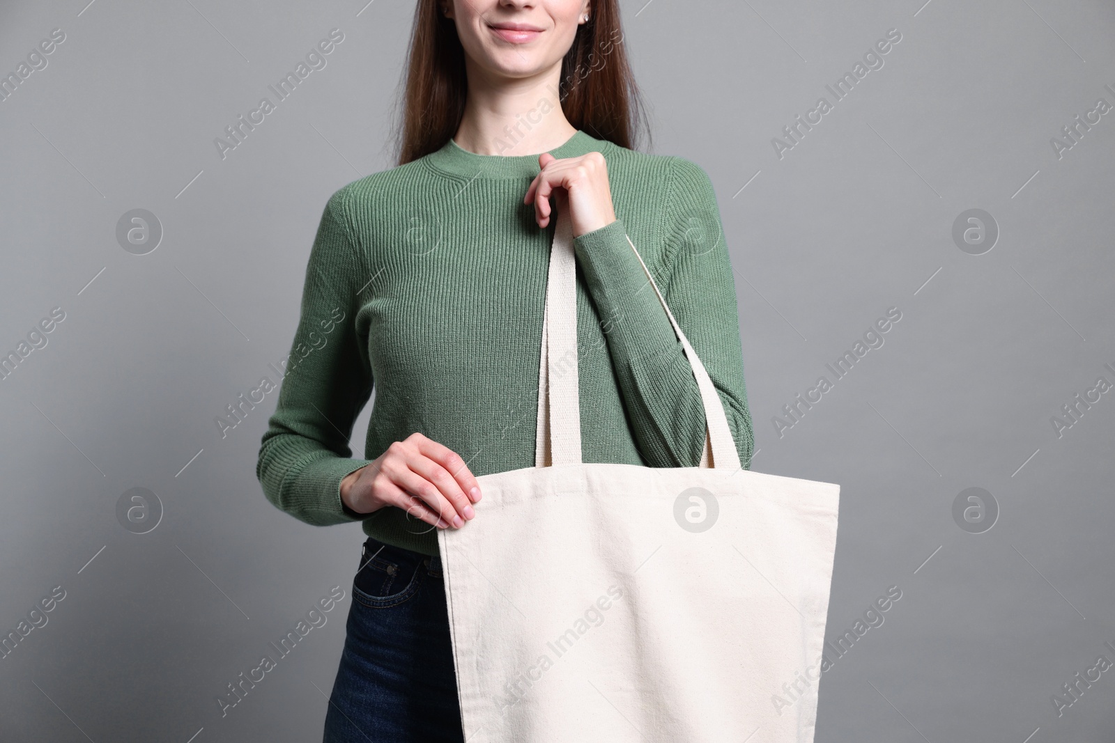 Photo of Woman with blank shopper bag on grey background, closeup. Mockup for design