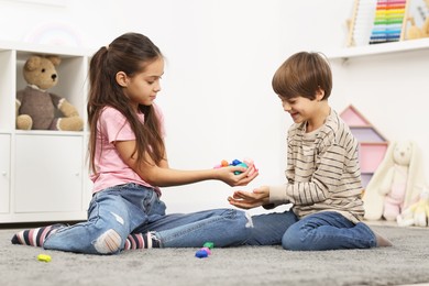 Children playing with balancing stones on floor indoors