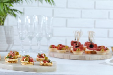 Photo of Many different tasty canapes on white wooden table