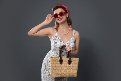 Photo of Happy pin-up woman with bag posing on grey background