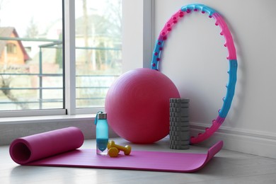 Different fitness equipment near white wall indoors