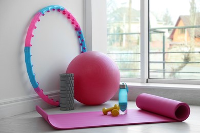 Photo of Different fitness equipment near white wall indoors