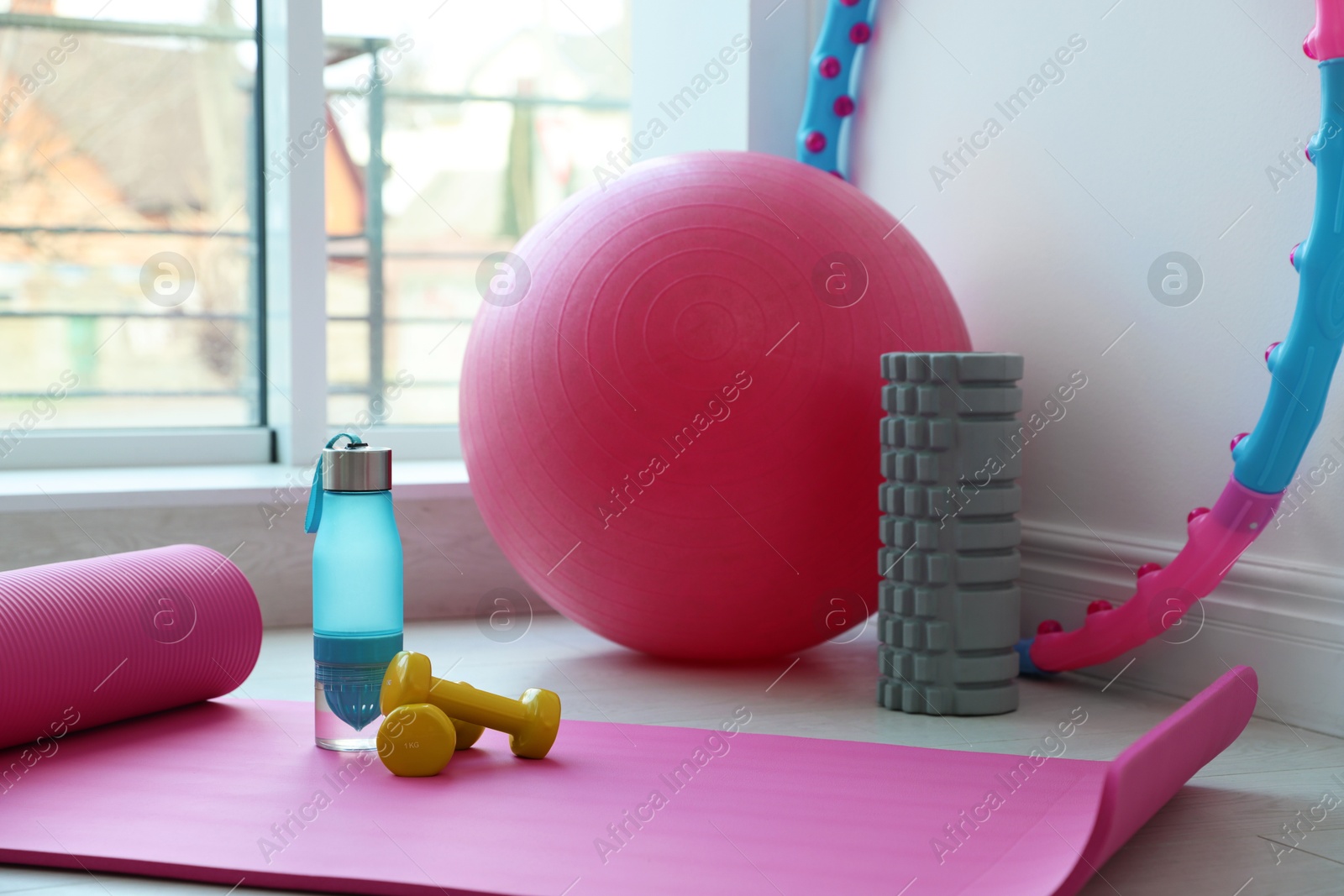 Photo of Different fitness equipment near white wall indoors