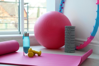 Different fitness equipment near white wall indoors