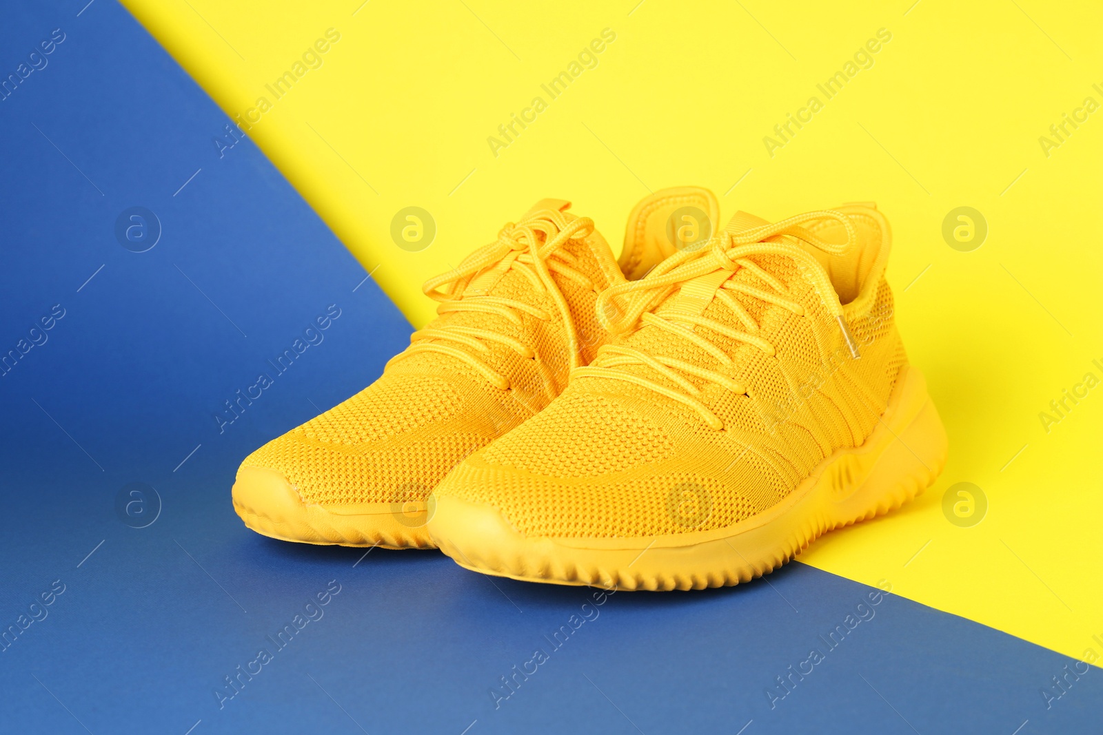 Photo of Pair of stylish sneakers on color background