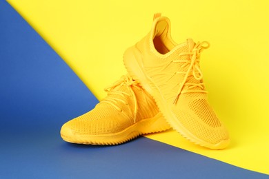 Photo of Pair of stylish sneakers on color background