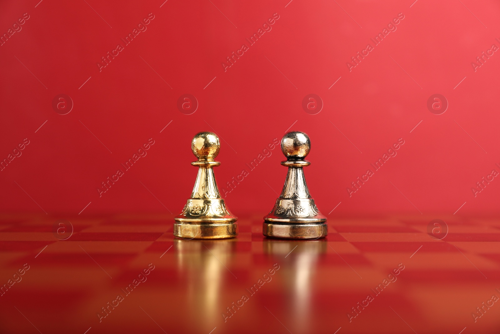 Photo of Golden and silver chess pawns in middle of chessboard. Competition concept