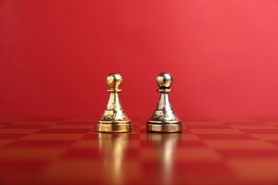 Photo of Golden and silver chess pawns in middle of chessboard. Competition concept