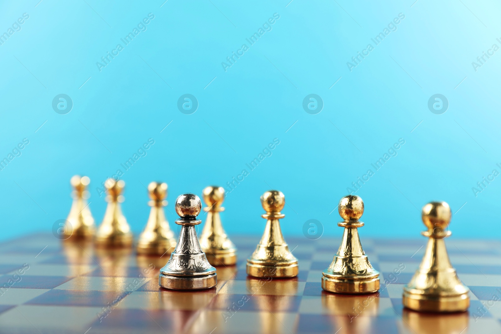 Photo of Silver pawn in front of golden ones on chessboard. Competition concept