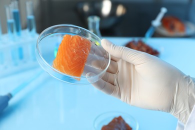 Photo of GMO concept. Scientist with piece of salmon in laboratory, closeup