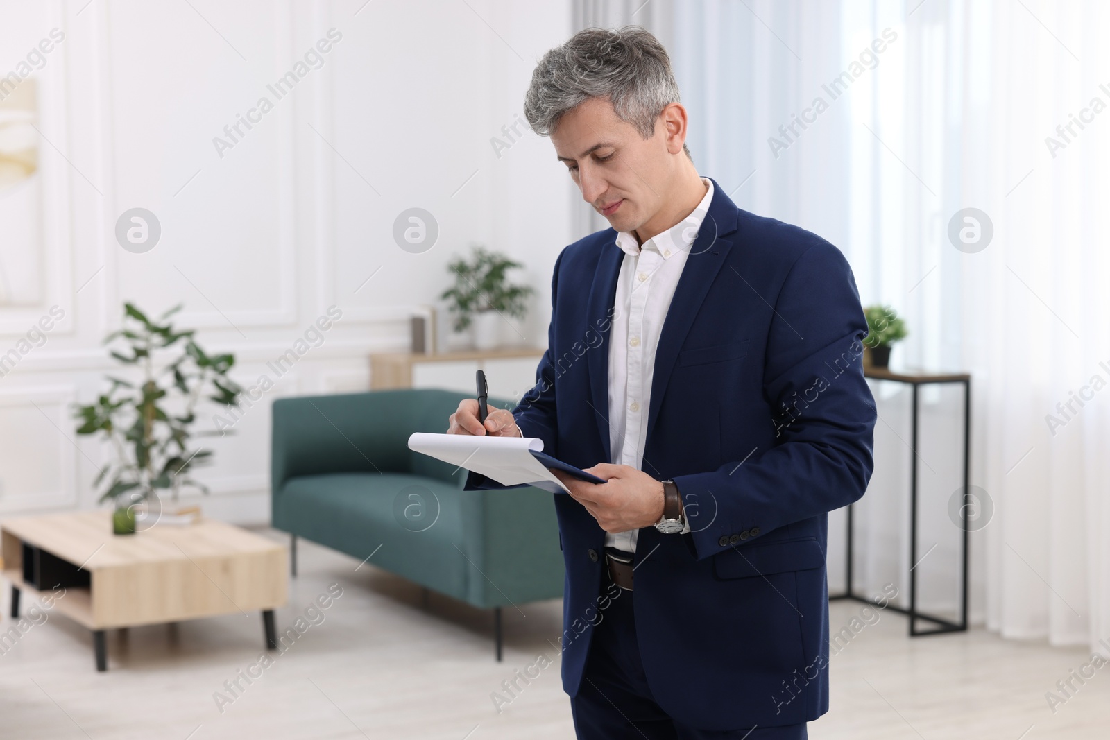 Photo of Real estate appraisal. Inspector with clipboard conducting property valuation at home. Space for text