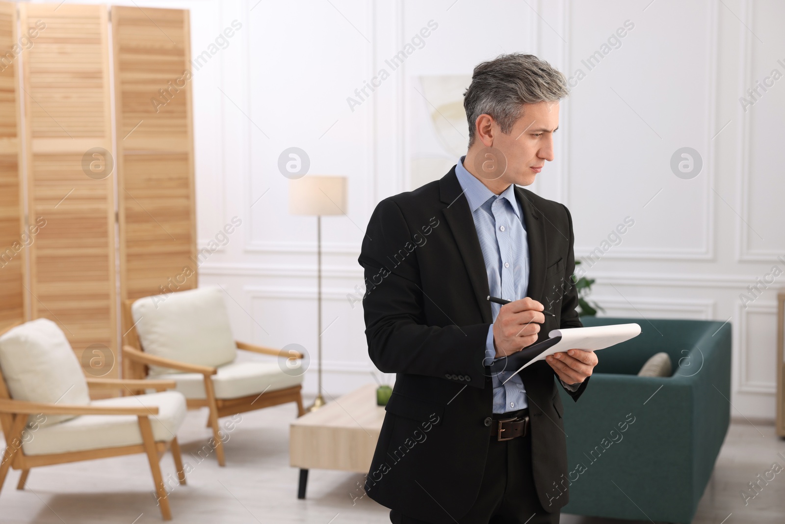 Photo of Real estate appraisal. Inspector with clipboard conducting property valuation at home. Space for text