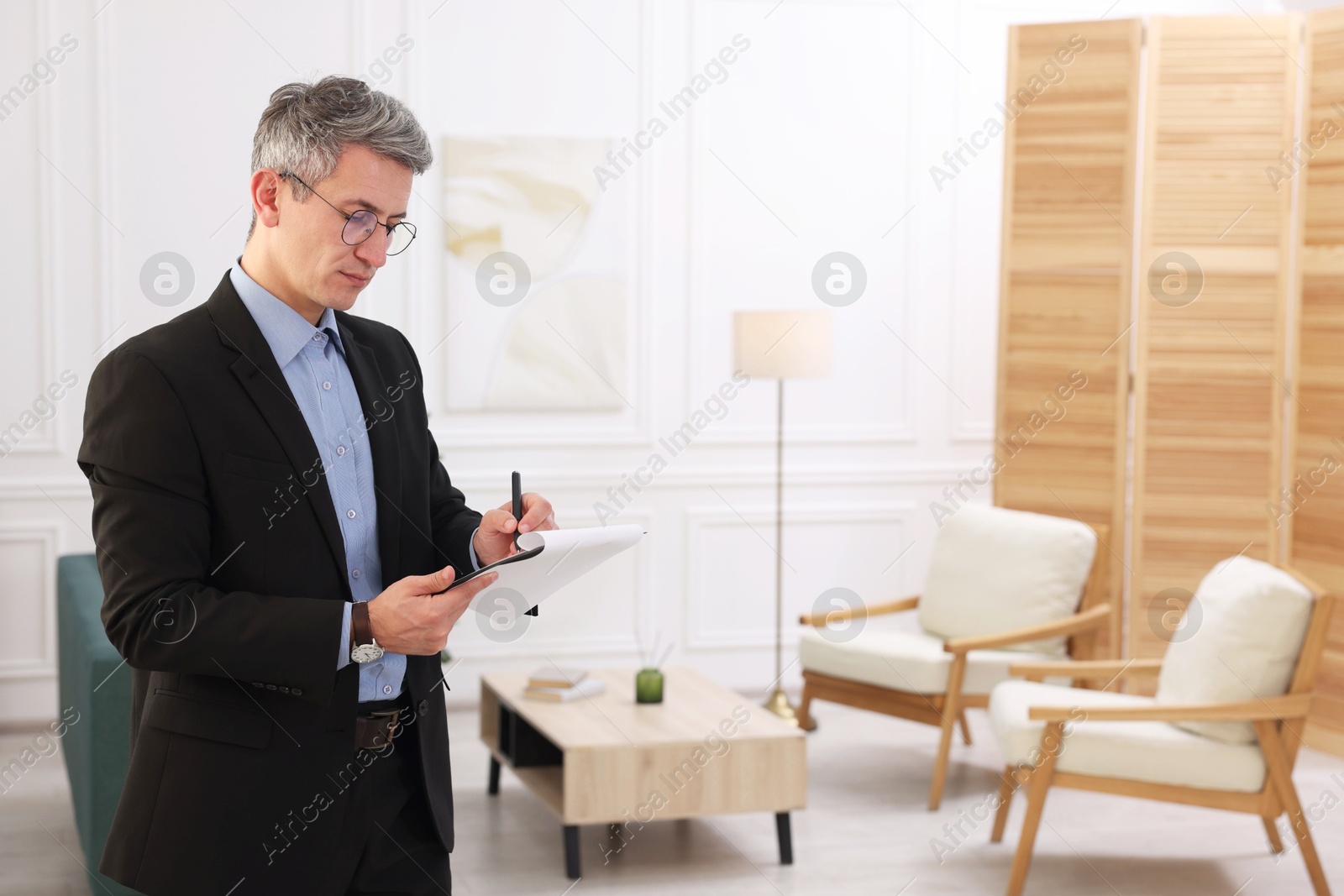 Photo of Real estate appraisal. Inspector with clipboard conducting property valuation at home. Space for text