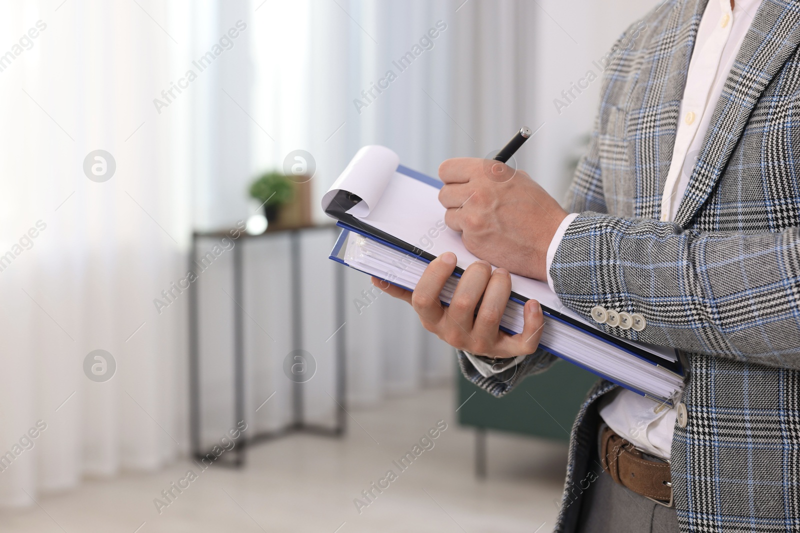 Photo of Real estate appraisal. Inspector with clipboard conducting property valuation at home, closeup. Space for text