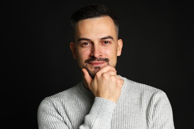 Photo of Portrait of handsome middle aged man on black background