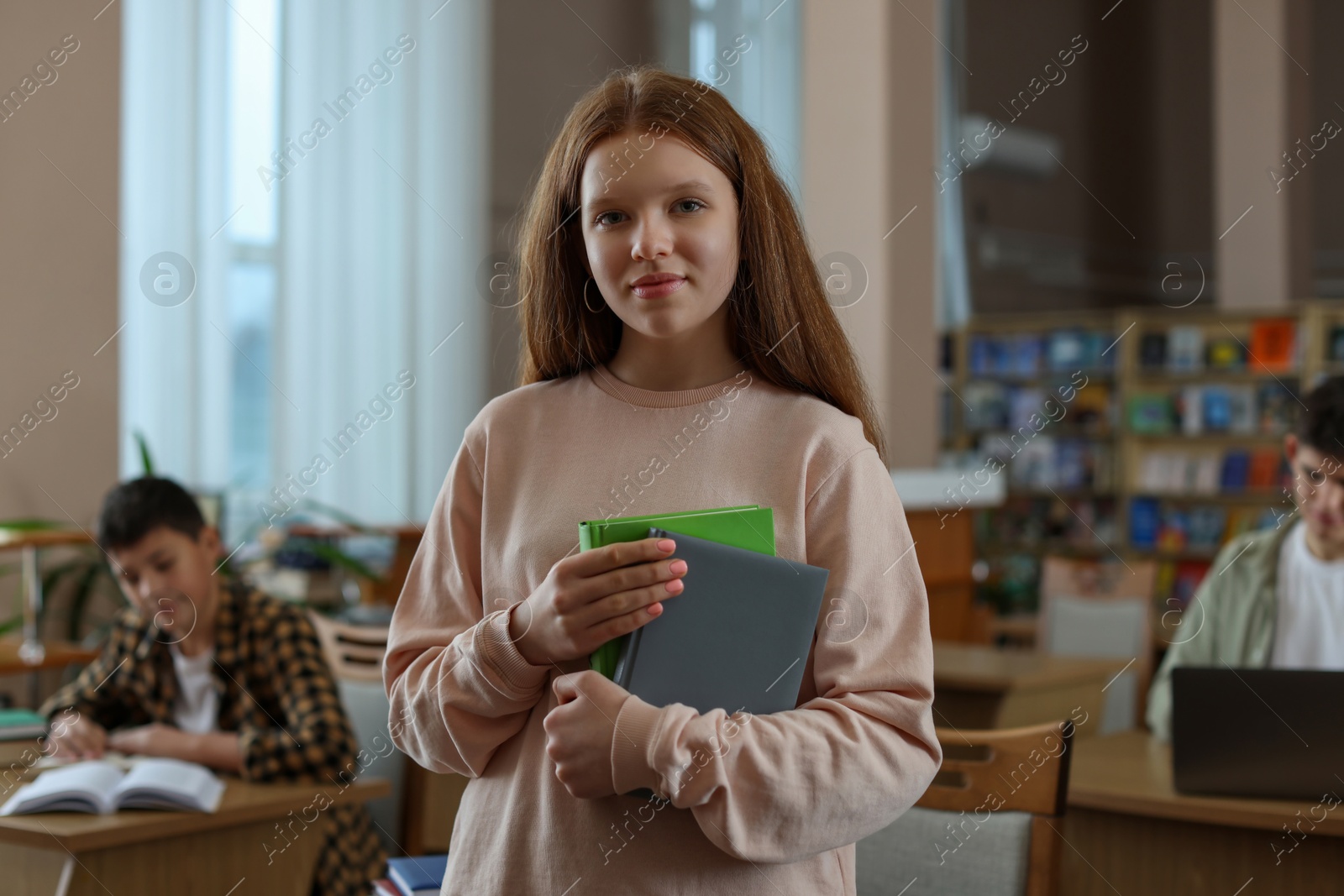 Photo of Beautiful girl with books in public library