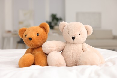 Photo of Cute teddy bears on bed in room, closeup