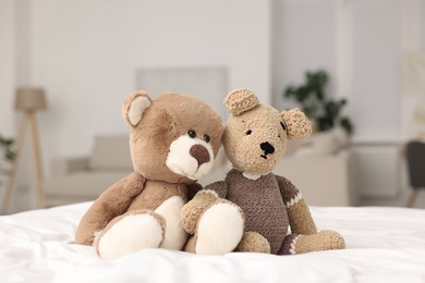 Photo of Cute toy bears on bed in room, closeup