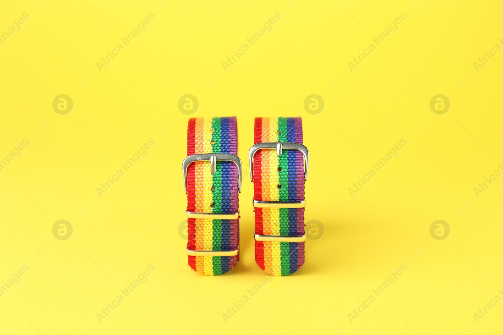 Photo of Two wristbands in LGBT colors on yellow background