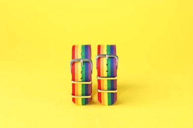 Photo of Two wristbands in LGBT colors on yellow background