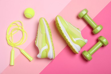 Photo of Different sports equipment and sneakers on pink background, flat lay