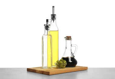 Photo of Salad dressings and olives on table against white background