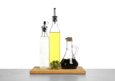 Photo of Salad dressings and olives on table against white background