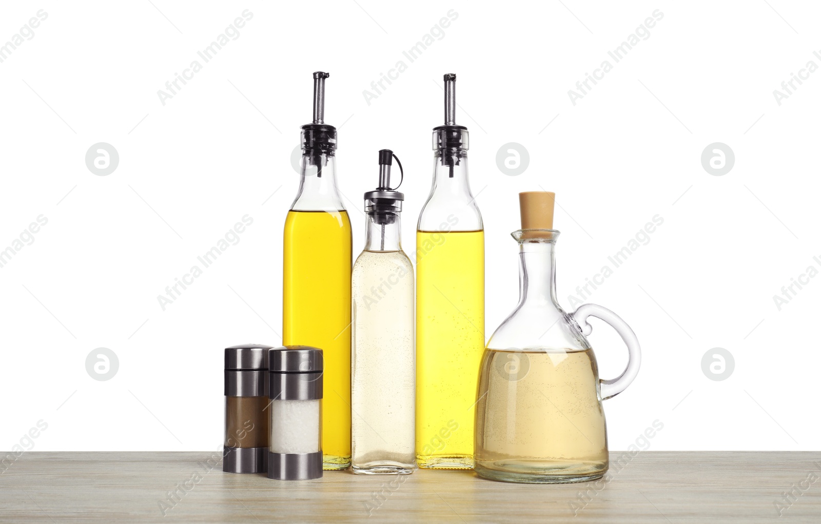 Photo of Salad dressings and spices on wooden table against white background