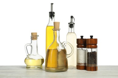 Photo of Salad dressings and spices on wooden table against white background