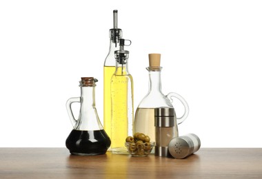 Photo of Salad dressings, spices and olives on wooden table against white background