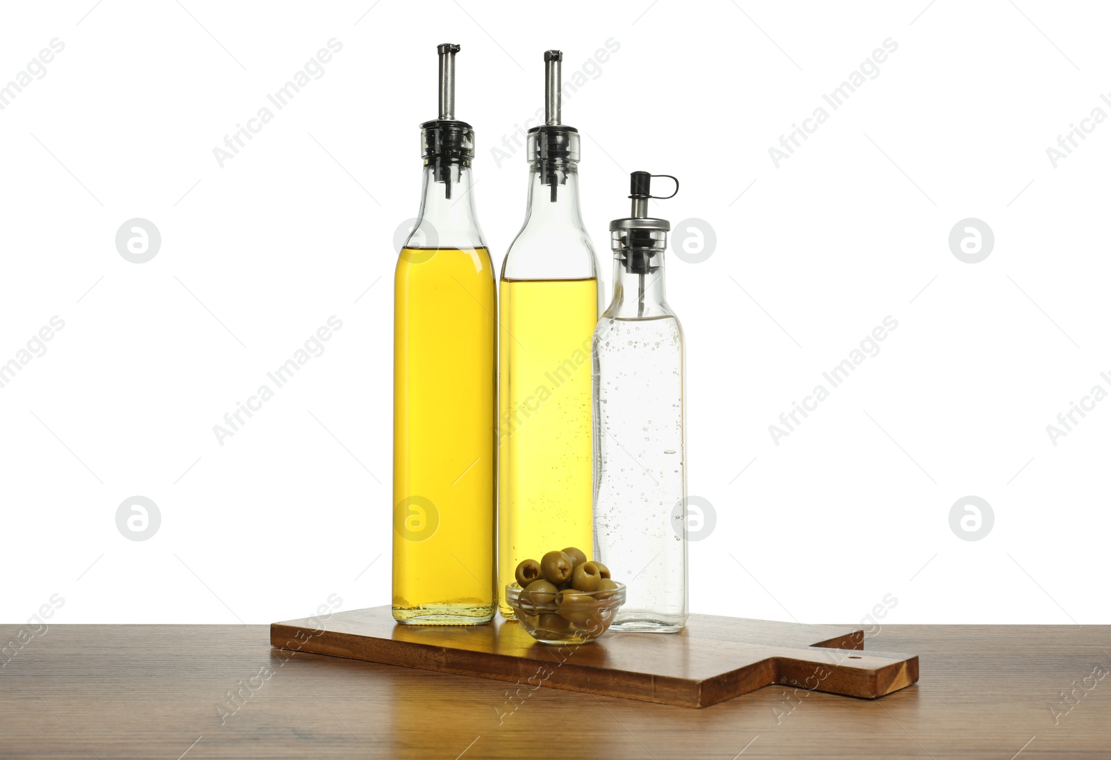 Photo of Salad dressings and olives on wooden table against white background