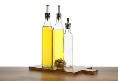 Photo of Salad dressings and olives on wooden table against white background