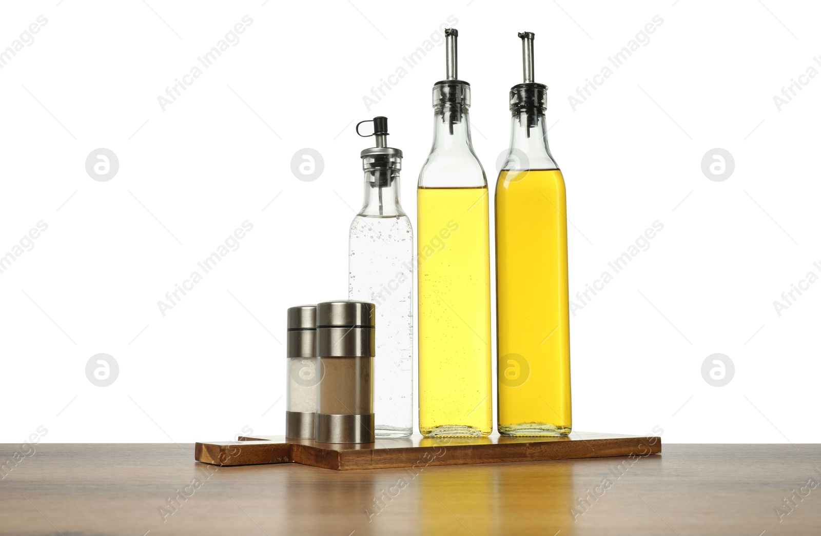 Photo of Salad dressings and spices on wooden table against white background