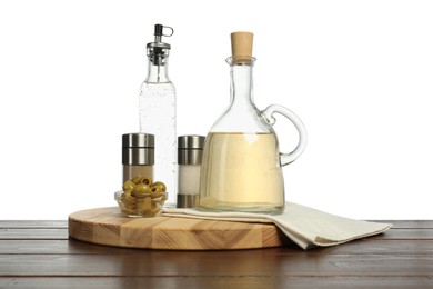 Photo of Salad dressings, olives and spices on wooden table against white background