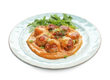 Photo of Delicious meatballs with gravy cream sauce, herbs and arugula isolated on white