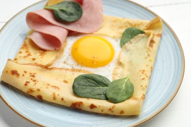 Photo of Delicious crepe with egg, ham and basil on table, closeup