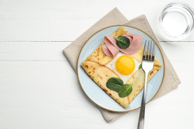 Photo of Delicious crepe with egg, ham, basil and water on white wooden table, flat lay. Space for text