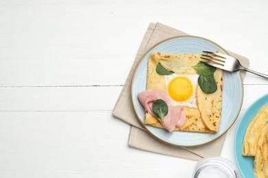 Photo of Delicious crepes with egg, ham, basil and water on white wooden table, flat lay. Space for text