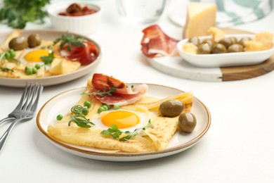 Photo of Delicious crepes with eggs and bacon served on white table, closeup